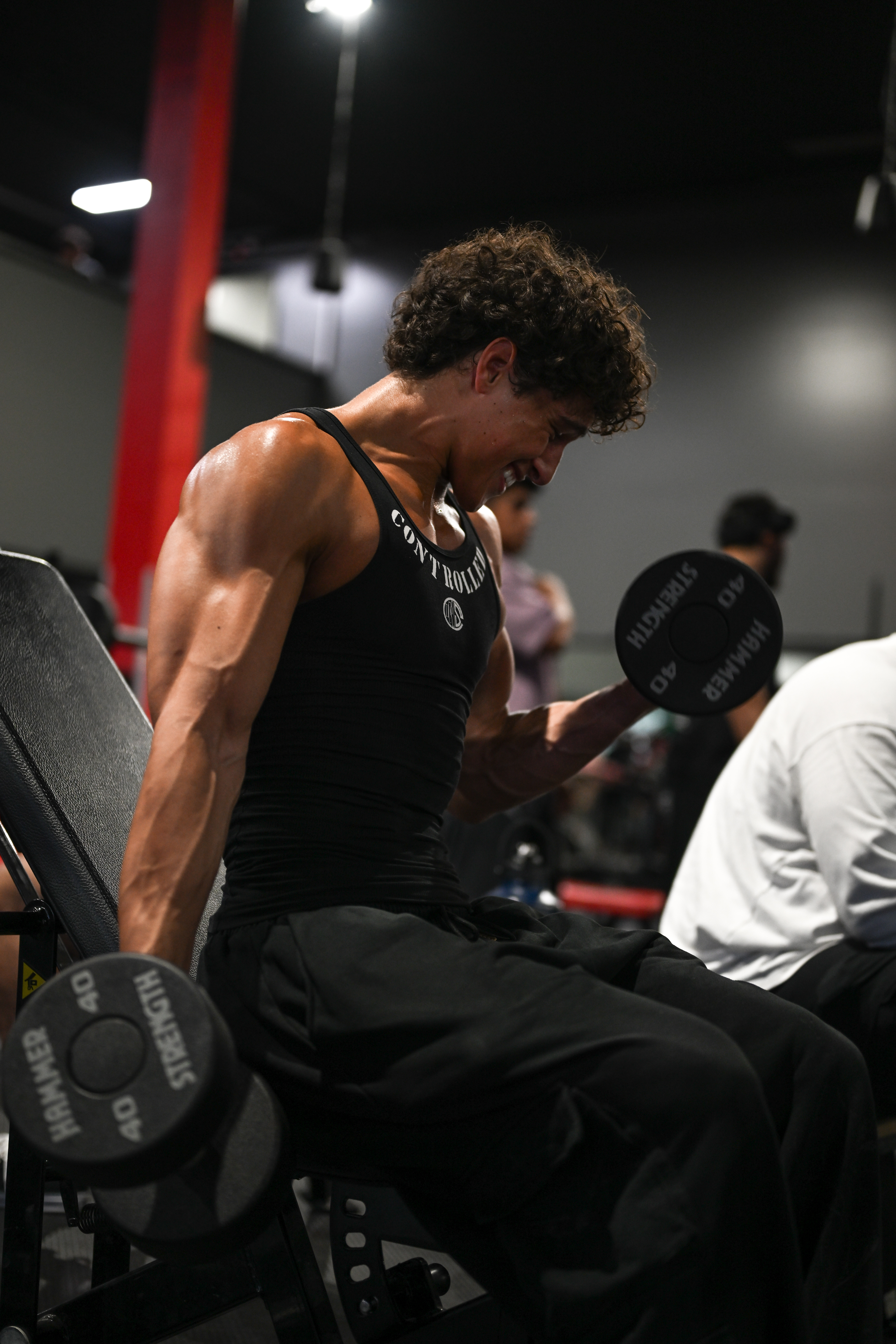 Athlete doing dumbbell curls in the gym