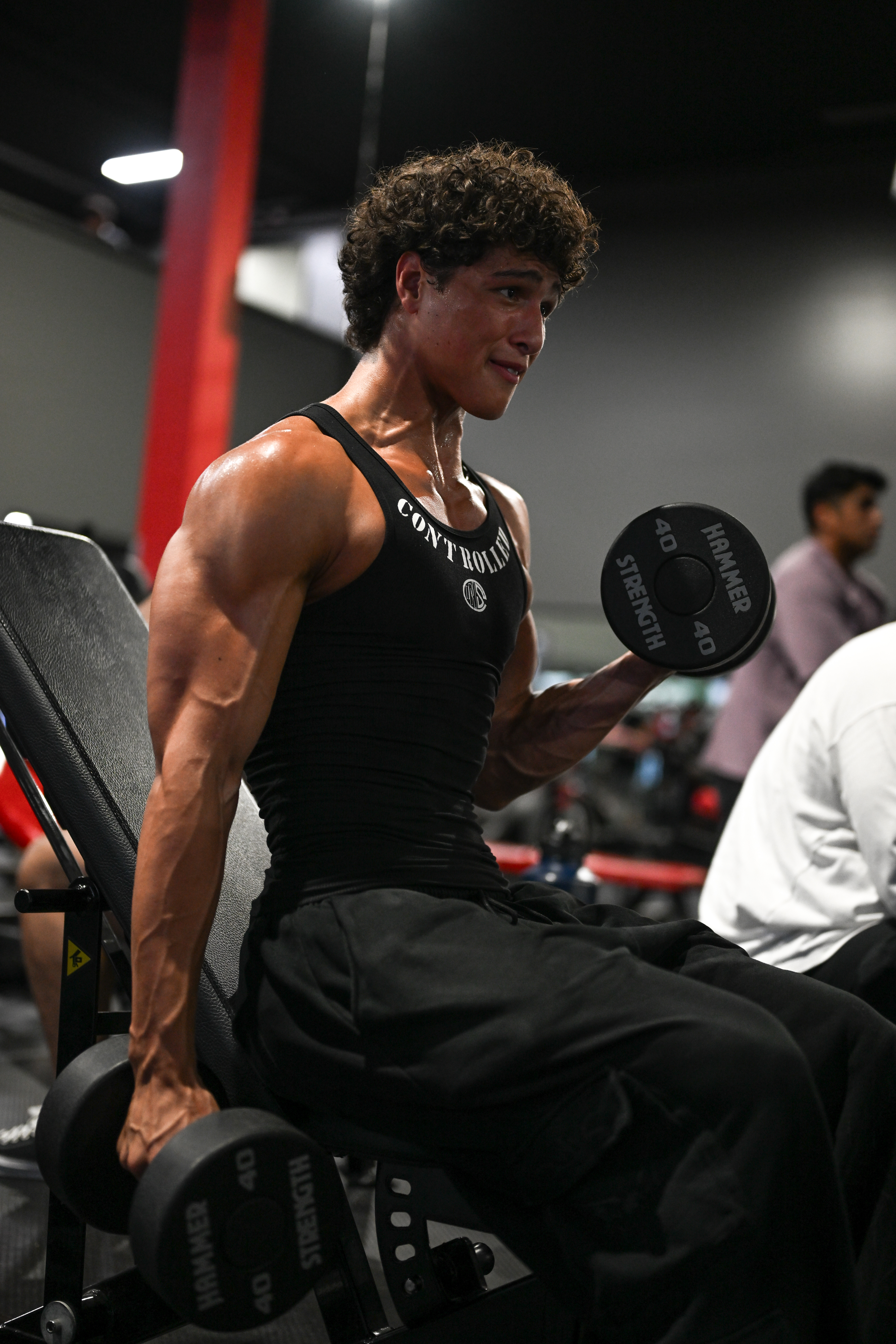 Athlete doing dumbbell curls, second angle